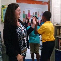 Jennifer Burnell high-fives students as they leave her classroom at Fall-Hamilton Elementary School. Credit: Chas Sisk / WPLN.